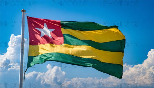 The flag of Togo flutters in the wind, isolated against a blue sky