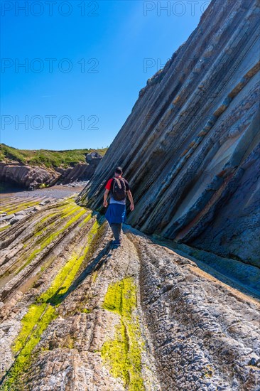 A male hiker visiting the Flysch Basque Coast geopark in Zumaia, Gipuzkoa