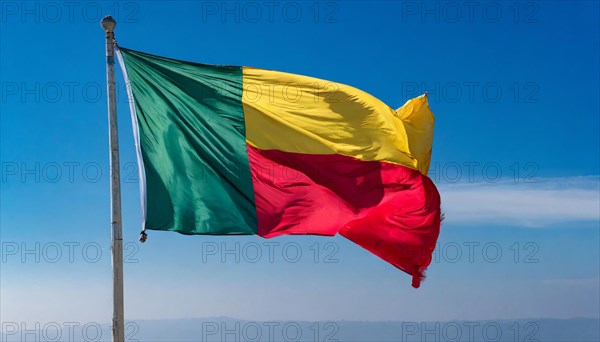 The flag of Benin flutters in the wind, isolated against the blue sky