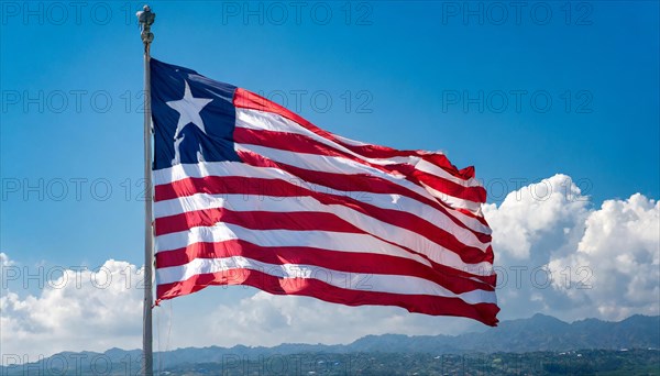 The flag of Liberia, fluttering in the wind, isolated, against the blue sky