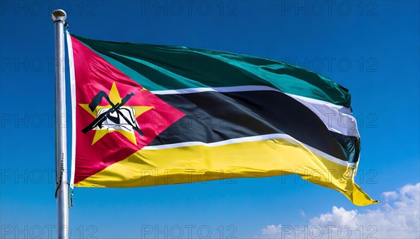 The flag of Mozambique, fluttering in the wind, isolated, against the blue sky