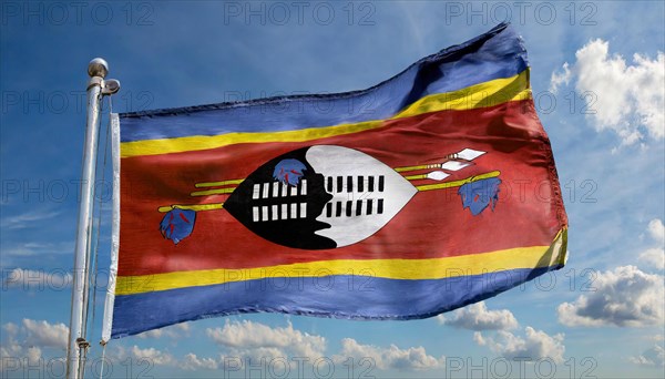 The flag of Swaziland, Kingdom of Eswatini, flutters in the wind, isolated, against the blue sky