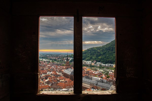 View over an old town with churches in the evening at sunset. This town lies in a river valley of the Neckar, surrounded by hills. Heidelberg, Baden-Wuerttemberg, Germany, Europe