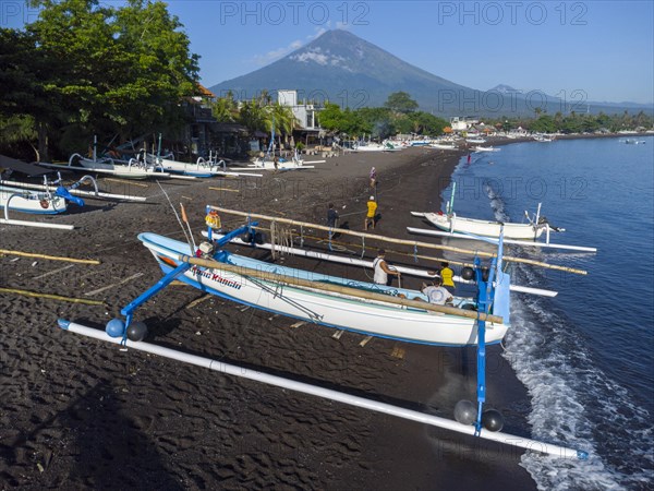 Fishermen loading fish from their outrigger boats in the morning on the black beach of Amed, Amed, Karangasem, Bali, Indonesia, Asia