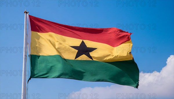 The flag of Ghana flutters in the wind, isolated against a blue sky