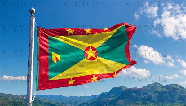 The flag of Grenada, Caribbean, flutters in the wind, isolated, against the blue sky