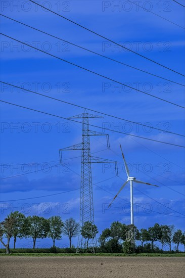 Electricity pylon with high-voltage lines and wind turbine on the K63 road with trees at the Avacon substation Helmstedt, Helmstedt, Lower Saxony, Germany, Europe