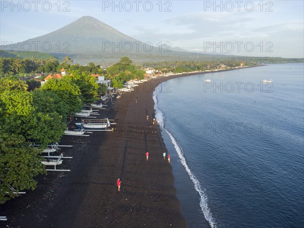 Fishermen loading fish from their outrigger boats in the morning on the black beach of Amed, Amed, Karangasem, Bali, Indonesia, Asia