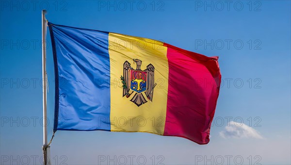 The flag of Moldova, Republic of Moldova, flutters in the wind, isolated against a blue sky