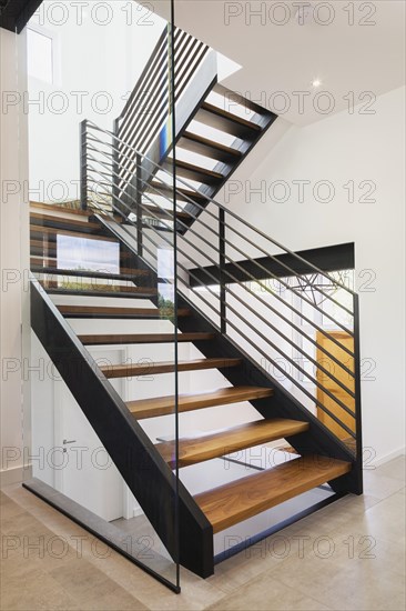 American walnut wood and black powder coated cold rolled steel stairs inside modern cube style home, Quebec, Canada, North America