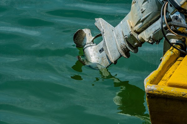 A highly detailed image showing the worn and corroded outboard motor of a boat, in South Korea