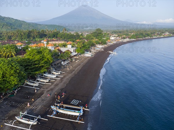 Fishermen unload their catch from their outrigger boat in the morning, in the background Gunung Agung, Amed, Karangasem, Bali, Indonesia, Asia