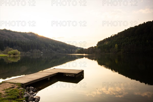 Lake at sunset. Beautiful landscape, taken from the shore of a reservoir. Situated in the middle of the forest and surrounded by nature, the reservoir offers a great atmosphere. Marbach Reservoir, Odenwald, Hesse, Germany, Europe