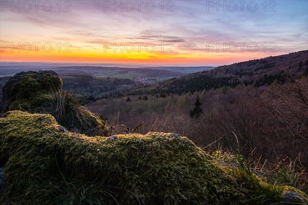 Panorama of a romantic landscape at sunset in the evening light. beautiful spring landscape in the mountains. Lawn and rolling hills. View from a cliff to the horizon. The Great Peak, Hesse, Germany, Europe