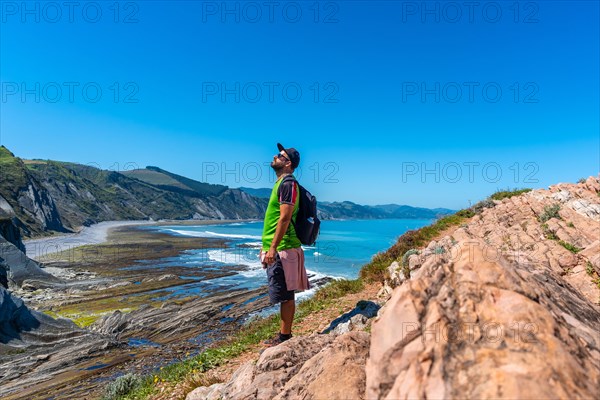 A man in Algorri cove on the coast in the Zumaia flysch without people, Gipuzkoa. Basque Country