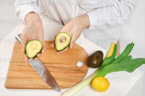 Unrecognizable woman holding avocado halves in her hands