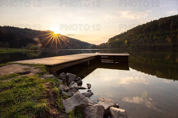 Lake at sunset. Beautiful landscape, taken from the shore of a reservoir. Situated in the middle of the forest and surrounded by nature, the reservoir offers a great atmosphere. Marbach Reservoir, Odenwald, Hesse, Germany, Europe