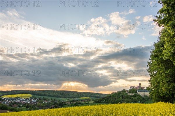 Landscape at sunrise. Beautiful morning landscape with fresh yellow rape fields in spring. Small castle in the yellow fields on a hill. Historic Ronneburg Castle in the middle of nature, Ronneburg, Hesse, Germany, Europe