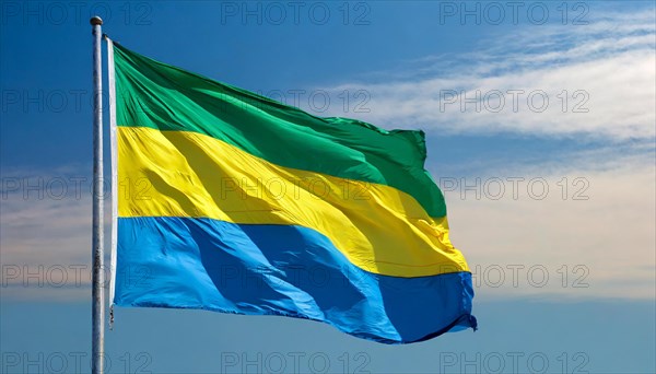 The flag of Gabon, fluttering in the wind, isolated, against the blue sky