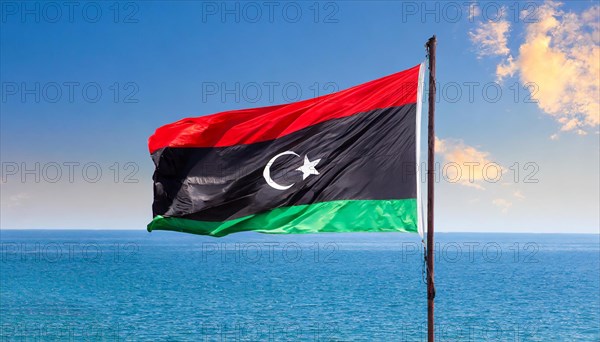 The flag of Libya, fluttering in the wind, isolated, against the blue sky