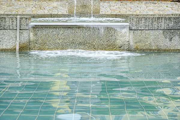 Water flows over the overflow of a water basin into another basin