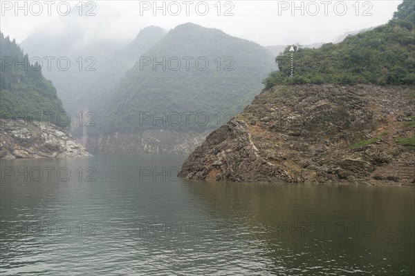 Cruise ship on the Yangtze River, Yichang, Hubei Province, China, Asia A river meandering through a misty, mountainous landscape with sparse vegetation, Asia