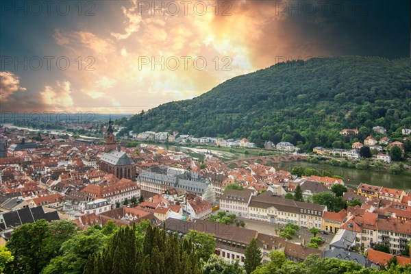 View over an old town with churches in the evening at sunset. This town lies in a river valley of the Neckar, surrounded by hills. Heidelberg, Baden-Wuerttemberg, Germany, Europe