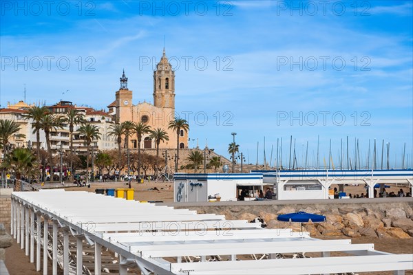 Beach, promenade with view of the church of St Bartholomew and St Thekla in Sitges, Spain, Europe