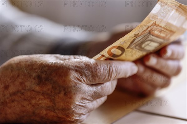 Wrinkled hands of a senior citizen with banknotes at home in her living room, close-up, Cologne, North Rhine-Westphalia, Germany, Europe