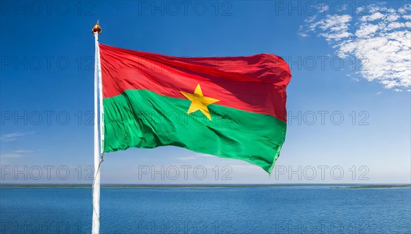 The flag of Burkina Faso flutters in the wind, isolated against the blue sky