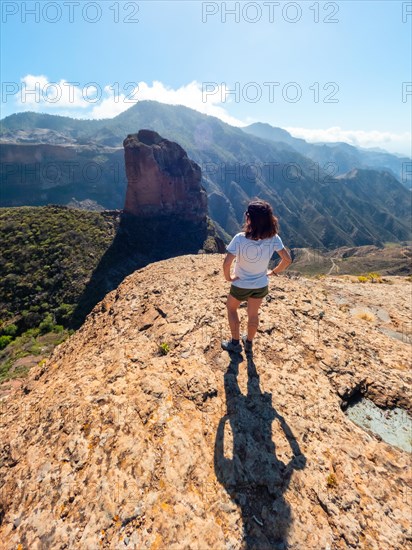A woman with her back turned at the Roque Palmes viewpoint near Roque Nublo in Gran Canaria, Canary Islands