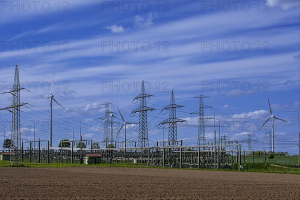 Power pylons with high-voltage lines and wind turbines at the Avacon substation in Helmstedt, Helmstedt, Lower Saxony, Germany, Europe