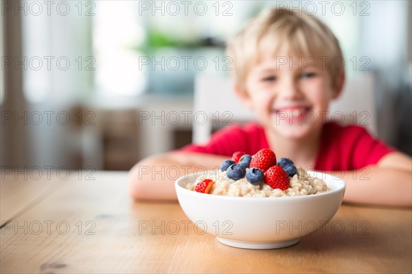 Bowl with oatmeal porridge and berry fruits an dhappy child at breakfast kitchen table. KI generiert, generiert, AI generated