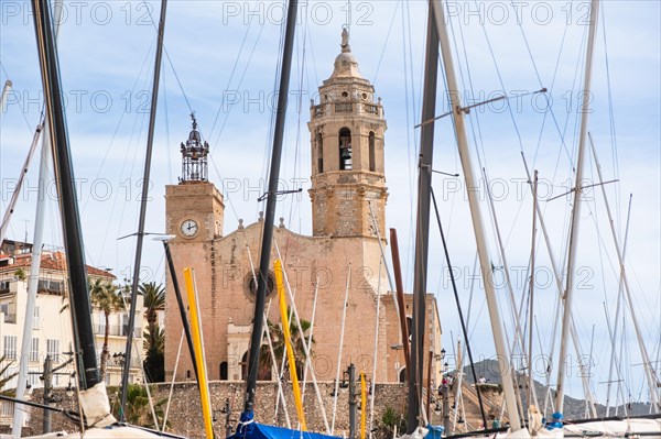 Beach, promenade with view of the church of St Bartholomew and St Thekla in Sitges, Spain, Europe