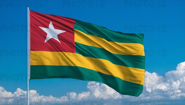 The flag of Togo flutters in the wind, isolated against a blue sky