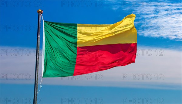 The flag of Benin flutters in the wind, isolated against the blue sky