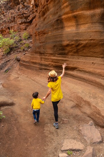 Family walking in the limestone canyon Barranco de las Vacas in Gran Canaria, Canary Islands