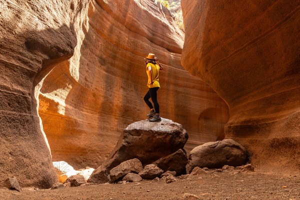 A woman in a yellow t-shirt in the limestone canyon Barranco de las Vacas in Gran Canaria, Canary Islands