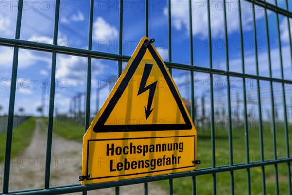 Yellow warning sign with the inscription Hochspannung Lebensgefahr! on a fence of the Avacon substation Helmstedt, Helmstedt, Lower Saxony, Germany, Europe