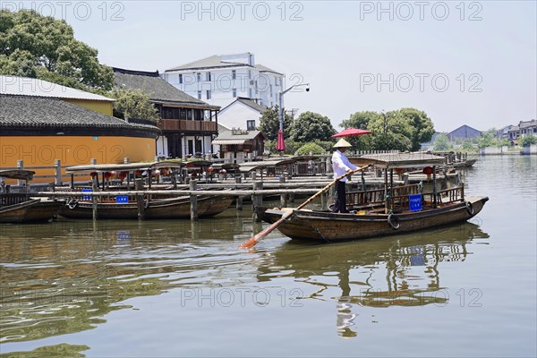 Excursion to Zhujiajiao water village, Shanghai, China, Asia, wooden boat on canal with view of historical architecture, view of a traditional boat on a wooden jetty on a calm river, Asia