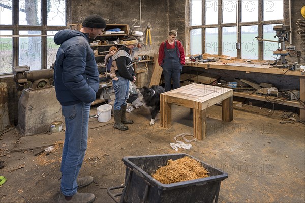 Family inspecting the table built by their son in the workshop, Mecklenburg-Vorpommern, Germany, Europe