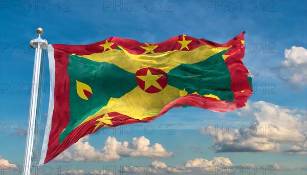 The flag of Grenada, Caribbean, flutters in the wind, isolated, against the blue sky