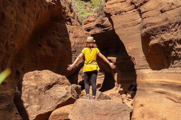 A woman with a hat in the limestone canyon Barranco de las Vacas on Gran Canaria, Canary Islands