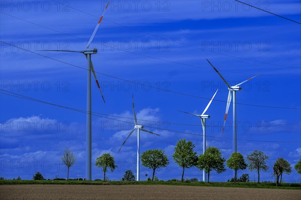 Wind turbines and high-voltage power lines on the K63 road with trees at the Avacon substation Helmstedt, Helmstedt, Lower Saxony, Germany, Europe
