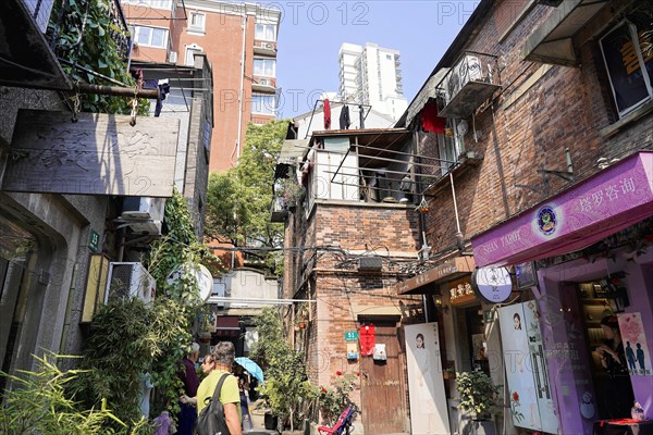Stroll through the restored Tianzifang neighbourhood, A narrow alley with traditional buildings and hanging laundry, Shanghai, China, Asia