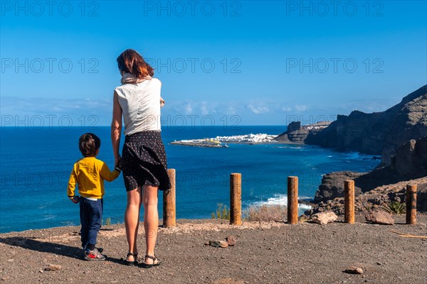 A mother and her son looking at Agaete from the Barraco de Guayedra viewpoint. Gran Canaria. Spain