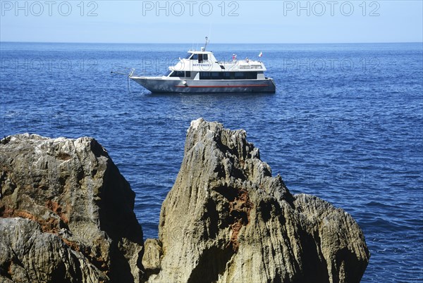 Excursion boat at the rocky coast of Capo Caccia with Grotta Nereo cave, Alghero, Sassari Province, Sardinia, Italy, Mediterranean Sea, South Europe, Europe