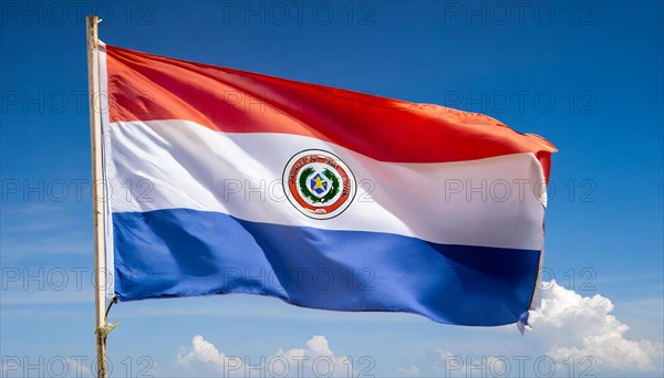 The flag of Paraguay flutters in the wind, isolated against a blue sky