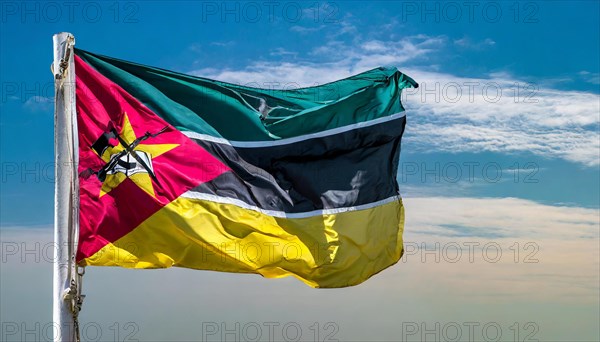 The flag of Mozambique, fluttering in the wind, isolated, against the blue sky