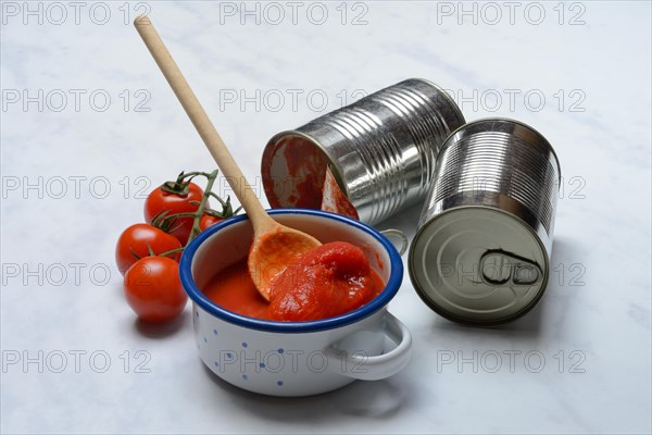 Tinned tomatoes in a bowl, tin can and tomatoes